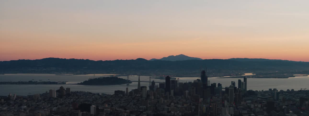 The city sits by the river in the distance