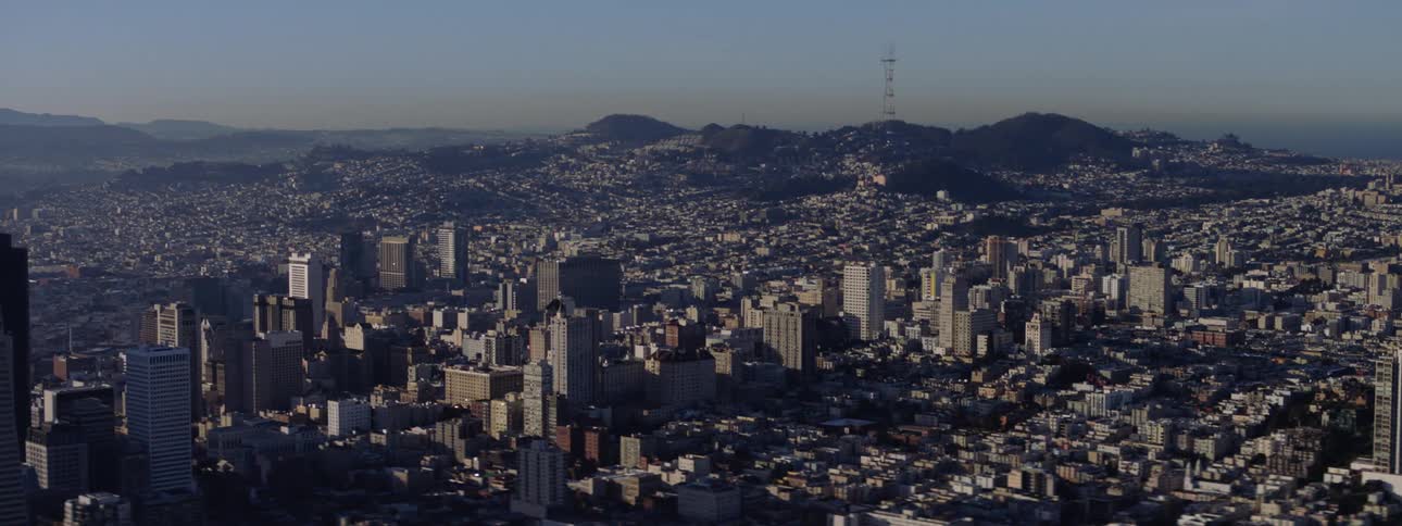 A sprawling city with dense neighborhoods and skyscrapers on a sunny day