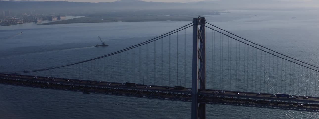Traffic moves across a suspension bridge over a bay