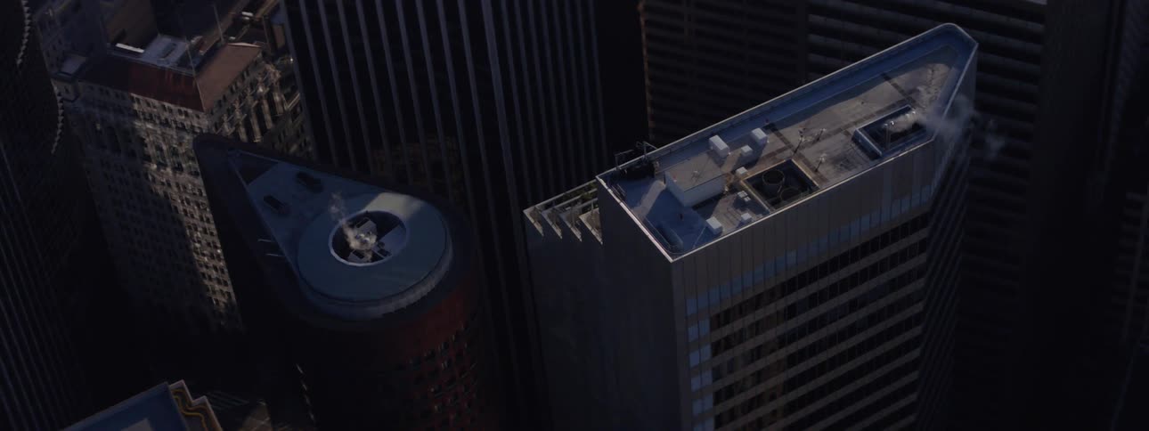 Smoke billows out of a vent on top of a skyscraper in the city