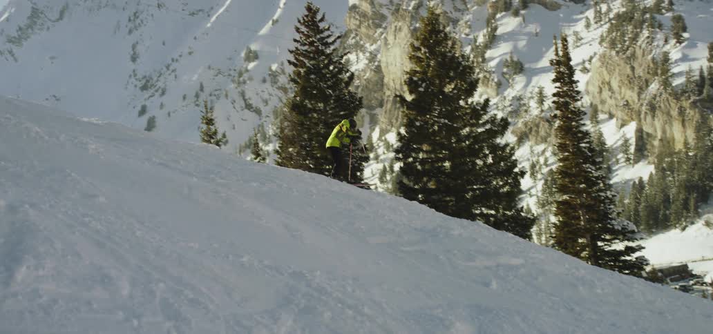 A person skis down a snowy mountain