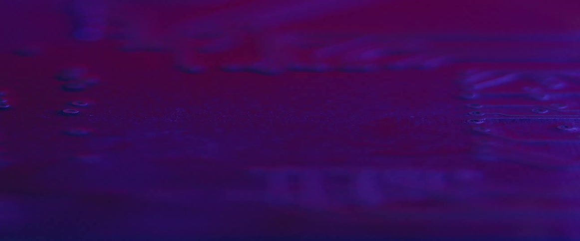 A circuit board is illuminated by purple light