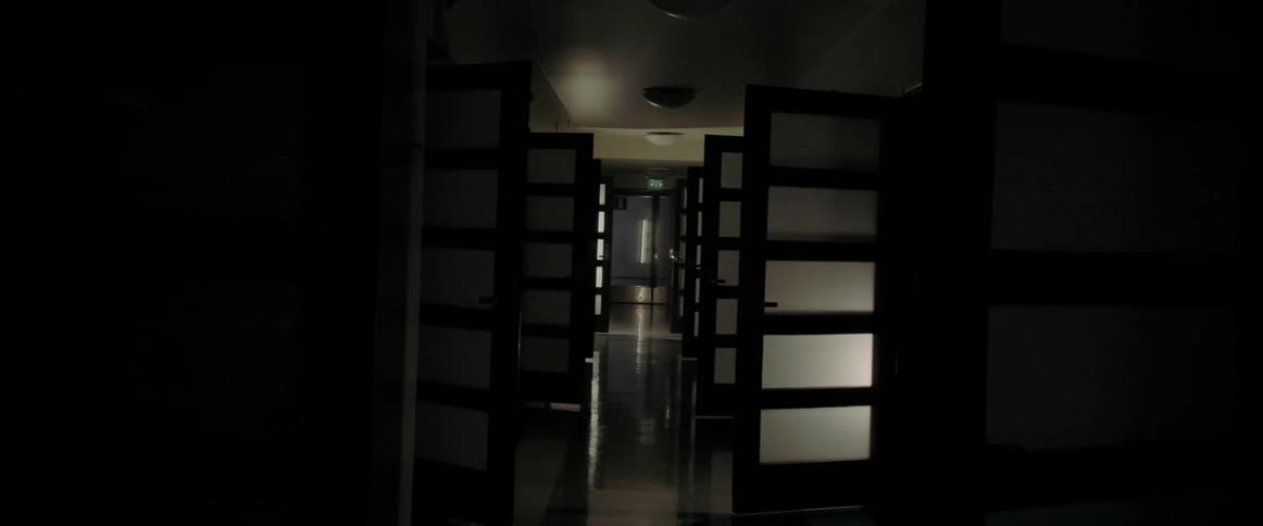 Lights flash to illuminate open doors in a corridor