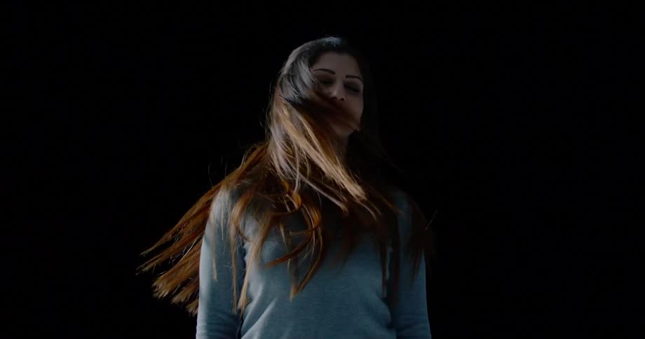 A white woman turns her head from side to side and whips her hair around