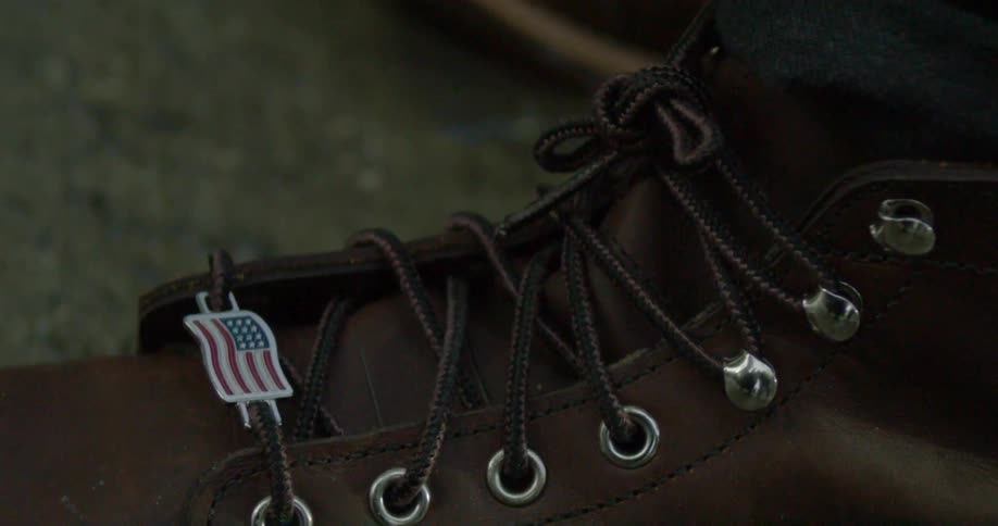 An american flag charm is laced onto a boot shoestring