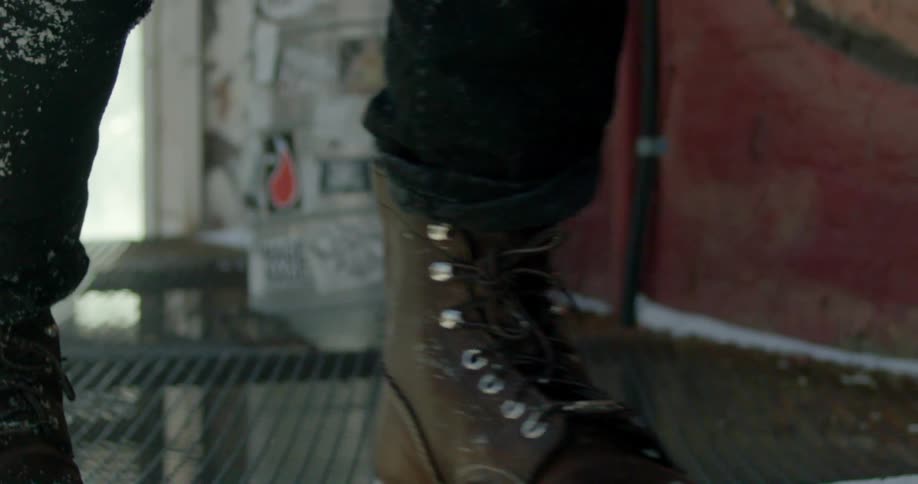 View of a person's feet as they run along metal grating