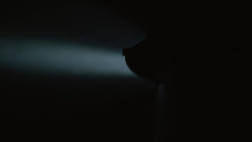 A firefighter shines a flashlight in the dark