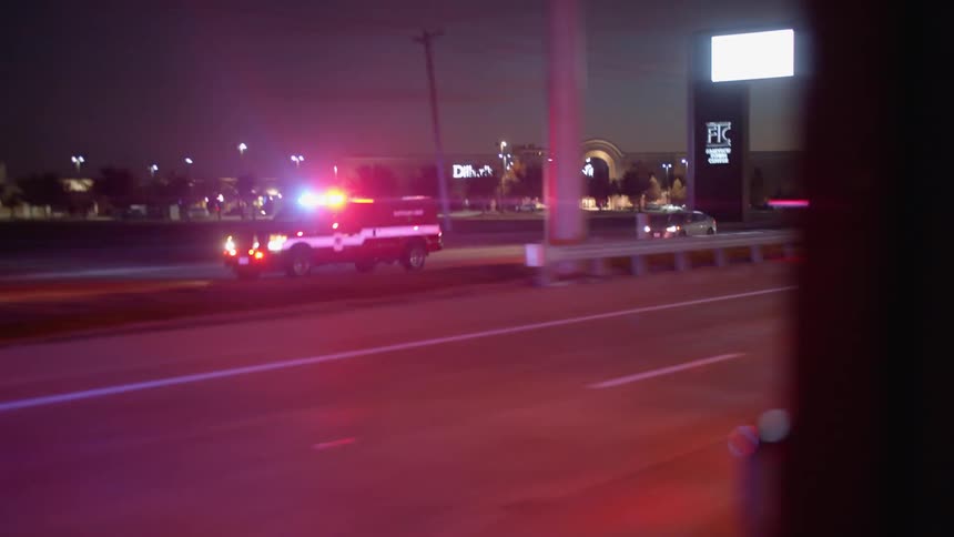An emergency vehicle drives down the street with lights flashing