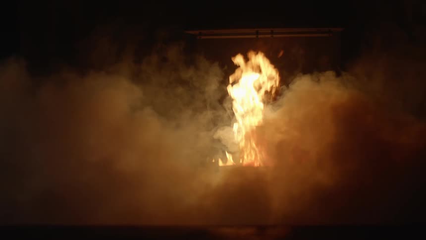 Smoke surrounds a fire in the night