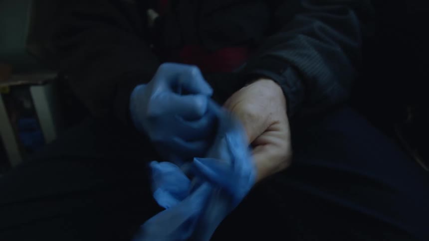 Person dons pair of medical gloves