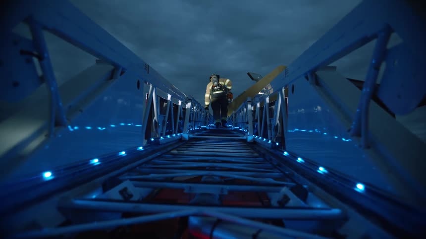 A firefighter climbs a lighted ladder