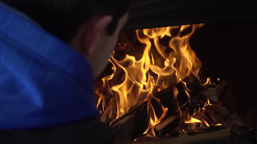 A person watching fire burning in a fireplace