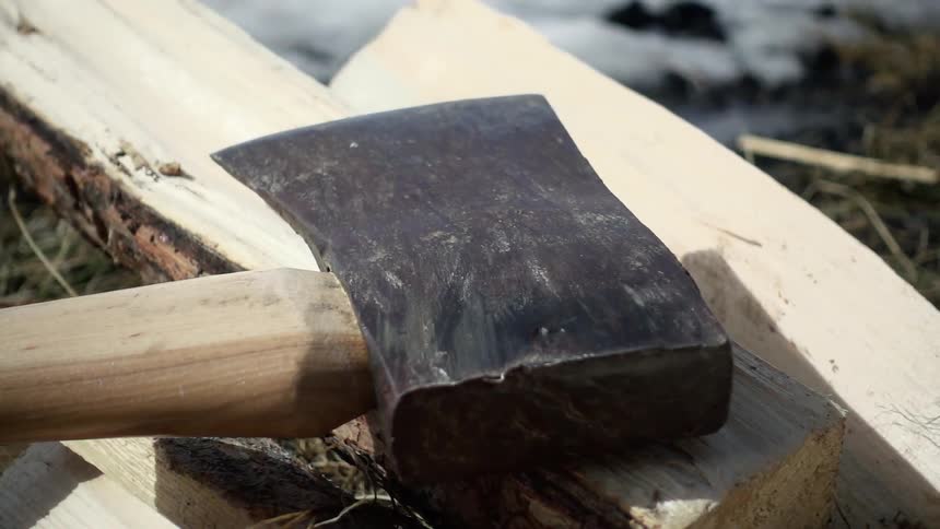 The ax is on the pile of wood