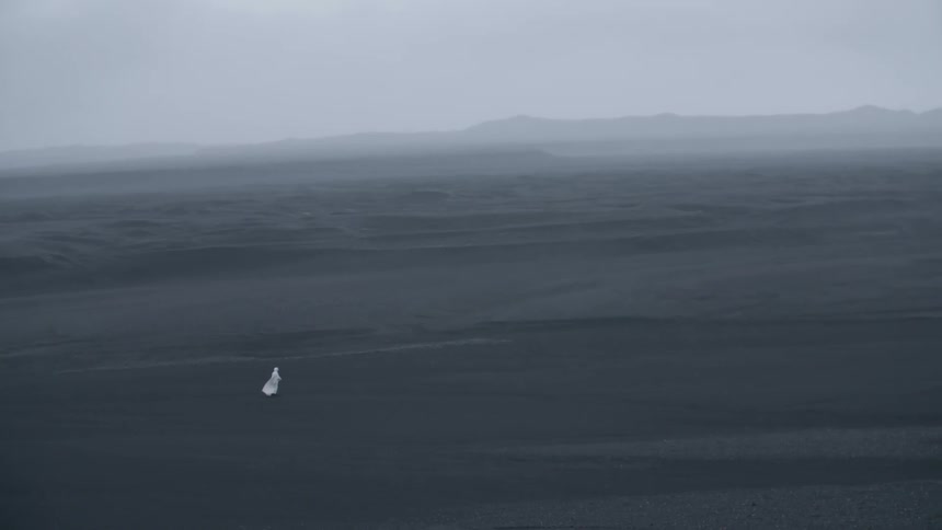 A large desert has one person traveling over it