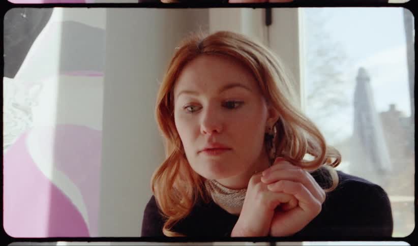 Red haired woman sitting on the stairs thinks about something in the living room at home
