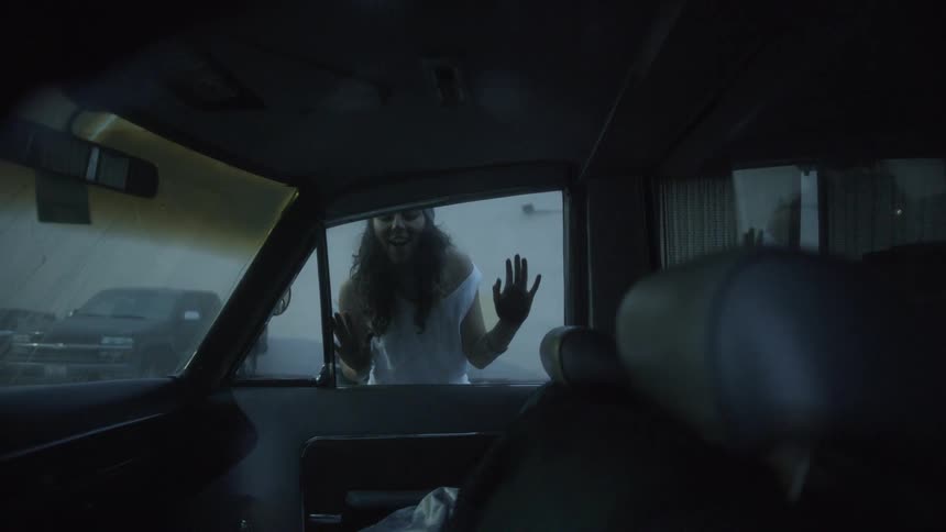 Woman looks inside the car and beams with pleasure
