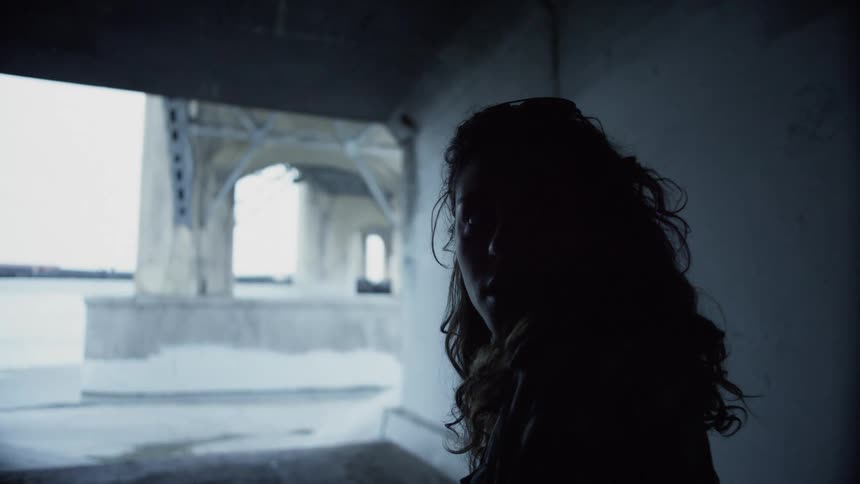 Silhouette of a woman looks around in a building