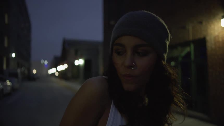 A teenager stands in a neighborhood street and looks around