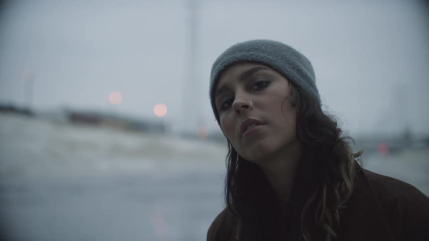 A woman with a nose ring and wearing a hat poses with attitude for the camera
