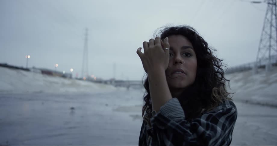 Portrait of a young woman under an overcast sky