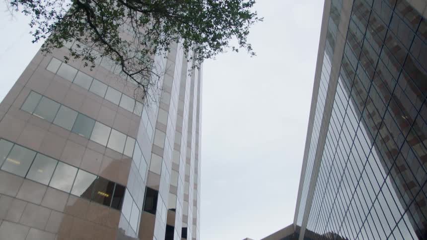 Vehicles drive along driveway after exiting the tunnel below the covered walkway that connects the office buildings together