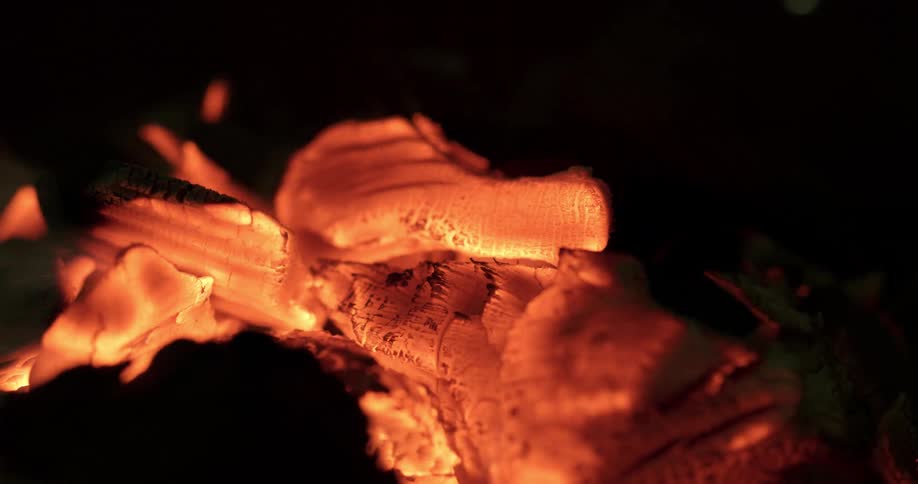 The campfire burns the wood slowly