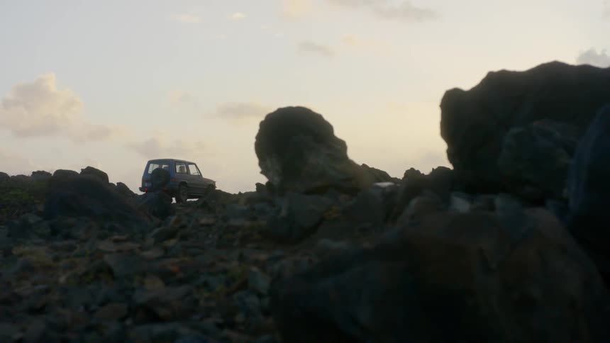 An off road vehicle parked on a cliff