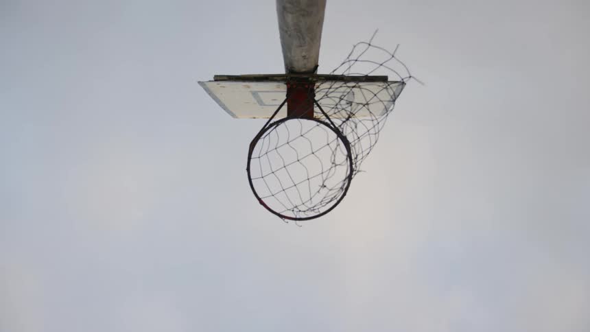 Man shoots basketball through hoop