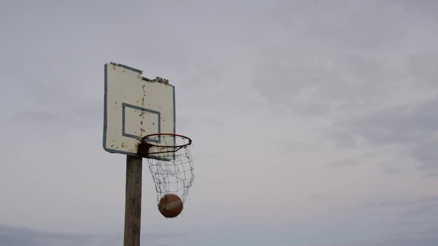 A basket ball goes through a basket ball hoop