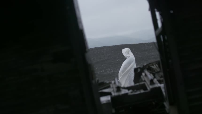 A person wearing white robes is standing on a field
