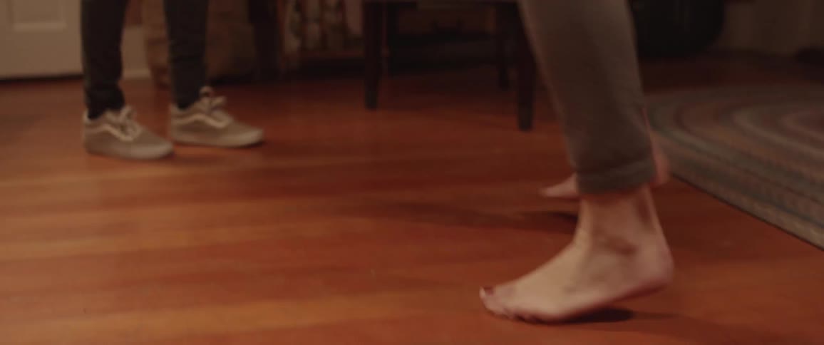 A pair of people dancing in the living room of a house