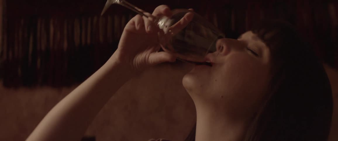 Side view of a sad woman drinking a glass of wine
