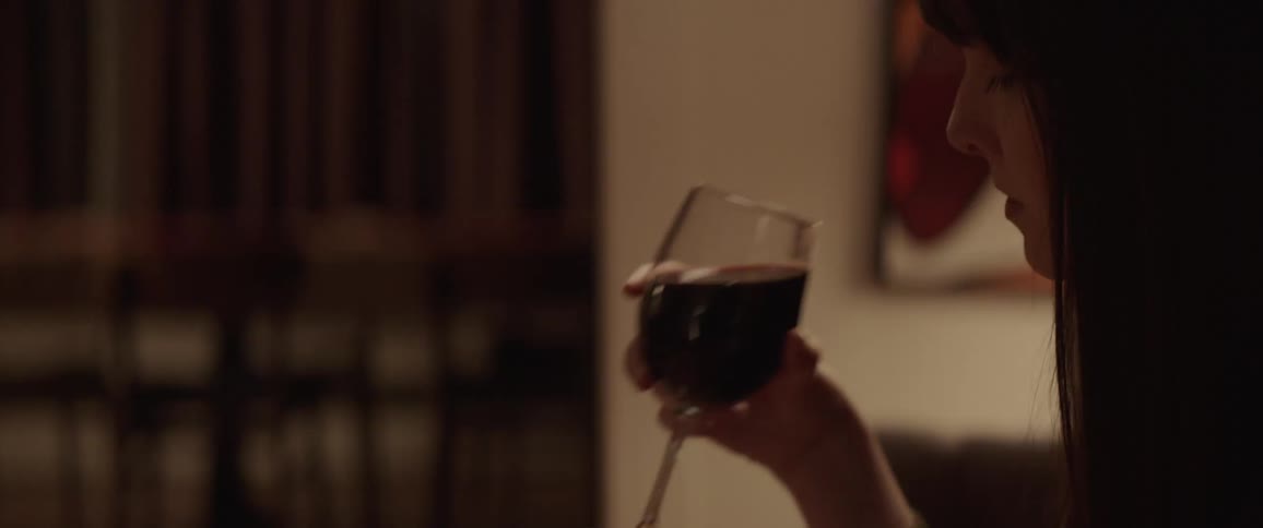 A woman takes a drink from her wine glass