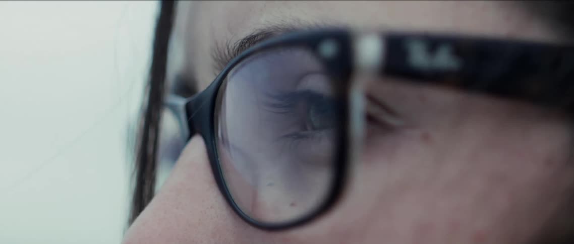 A white woman with glasses looks around