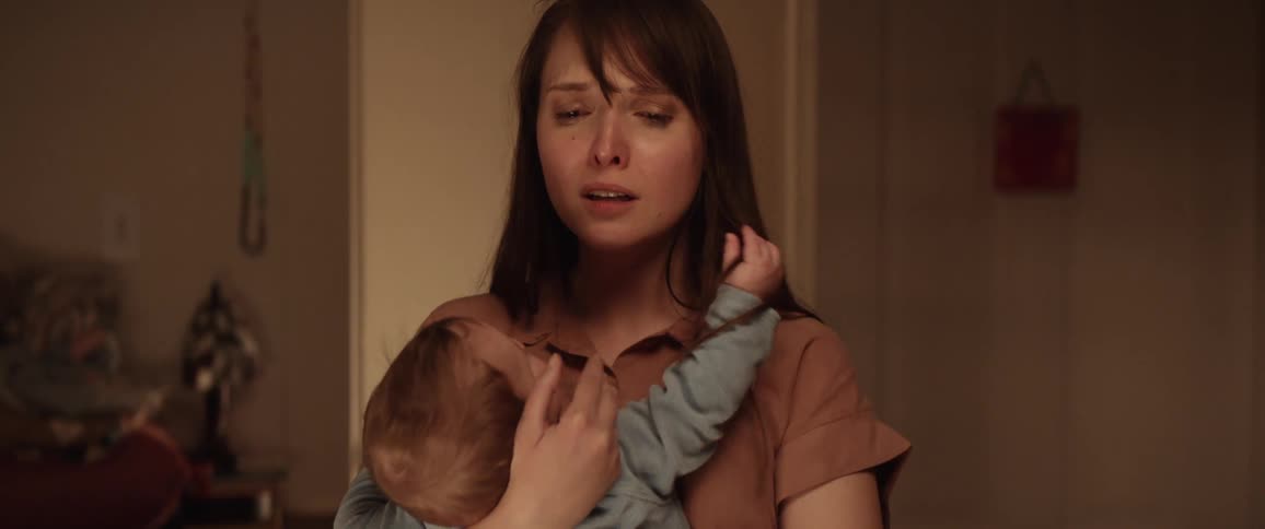 A sad Hispanic mother cradles her baby