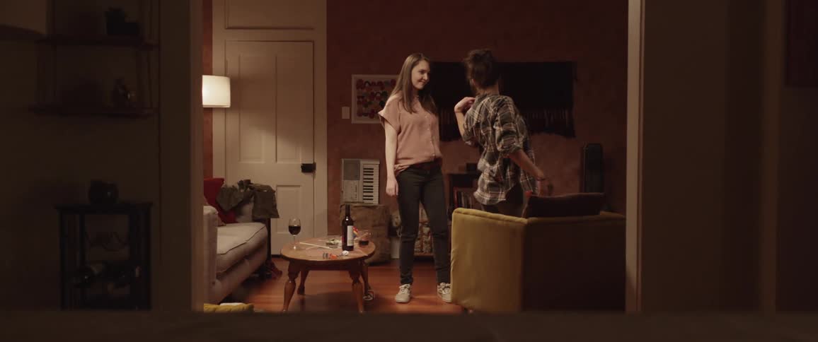 Two girls dance together in the living room at home