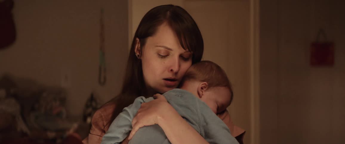 A mother holds and caresses her baby