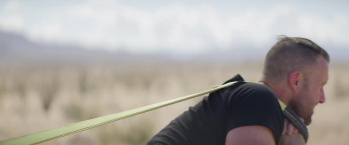 Man dragging something through the desert at day