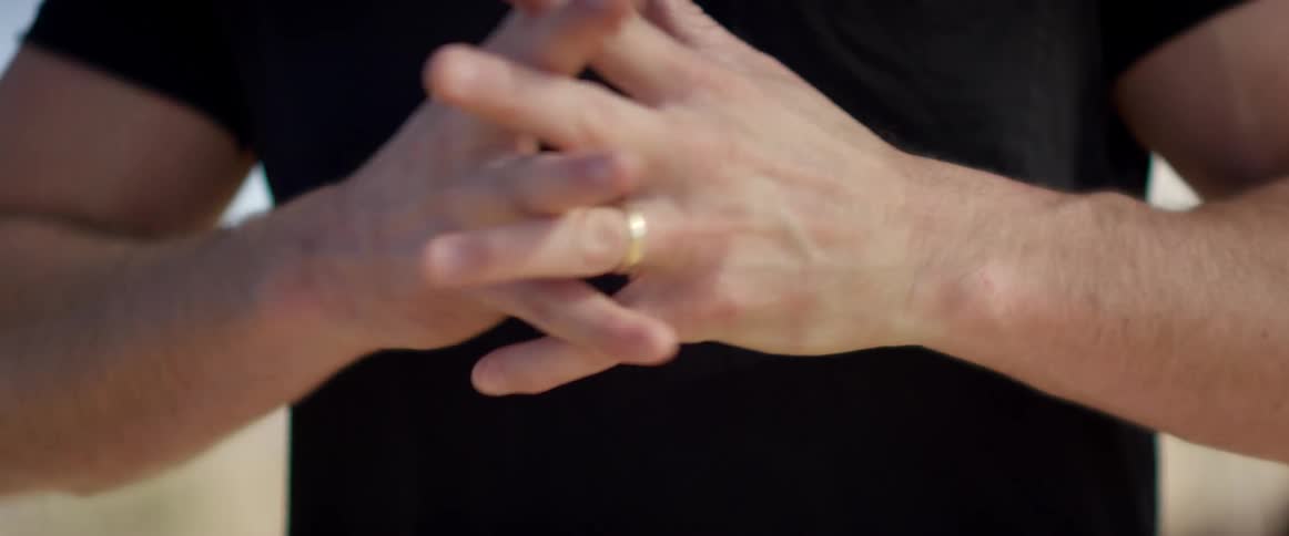 A man is stretching his arms indoors