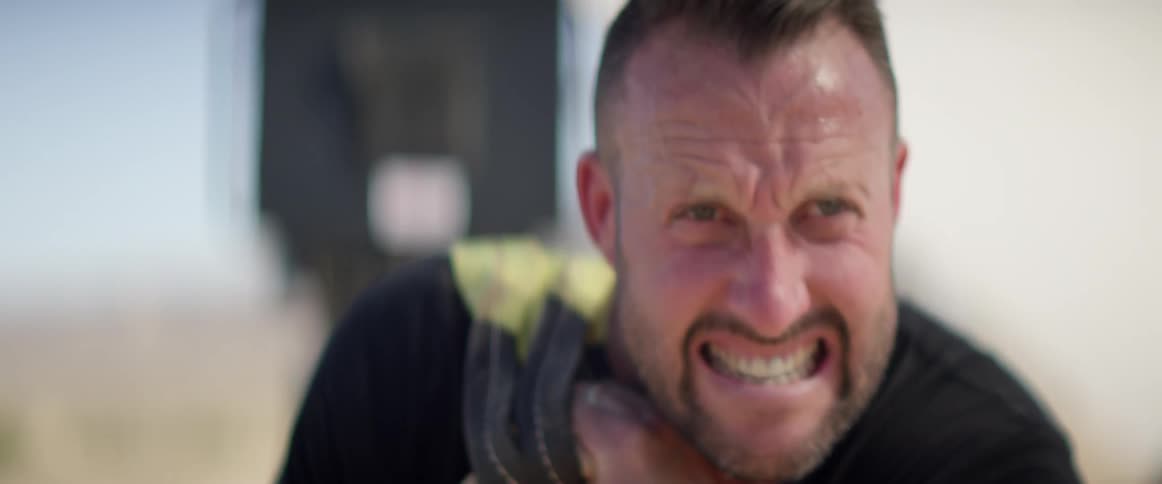 Man grimaces while straining to drag object
