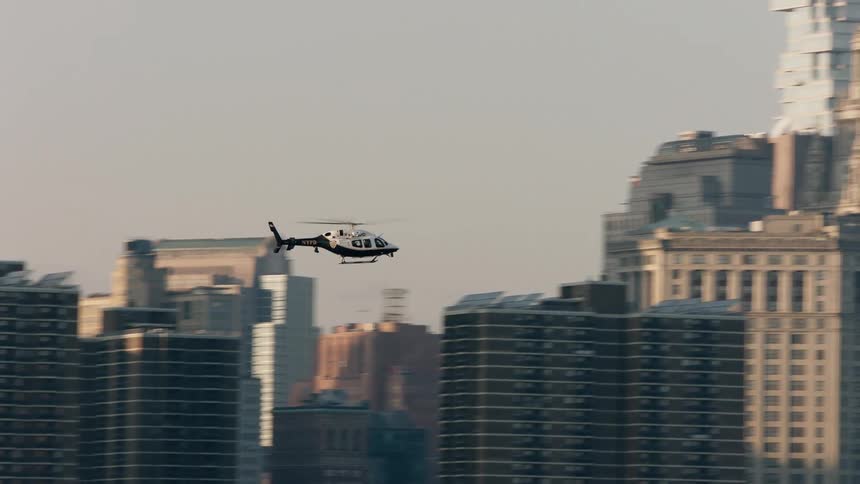 Helicopter flies through new york city at sunset