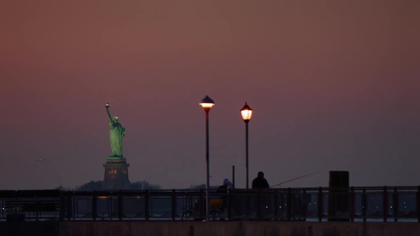 Two men fish over a railing off the coast of new york city