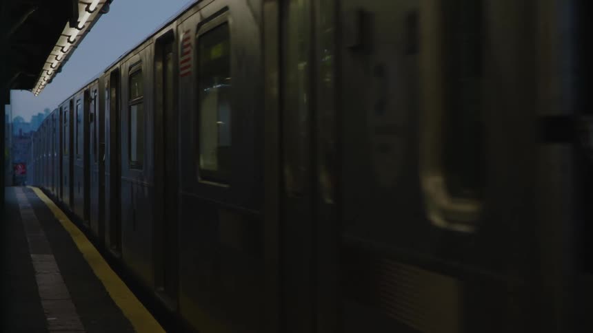 Train enters outdoors metro station in early dawn