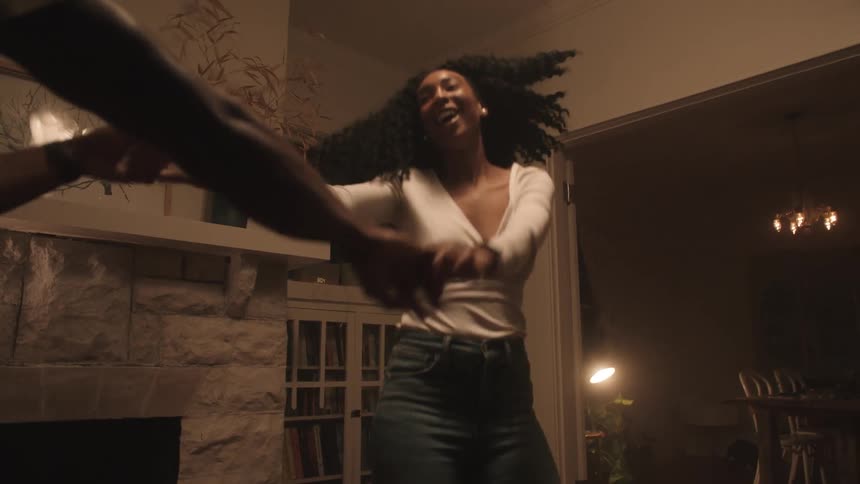 A man and woman are dancing in their house