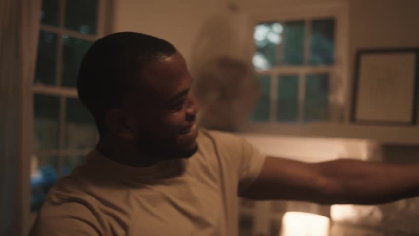 Black husband and wife dance together in the living room at home