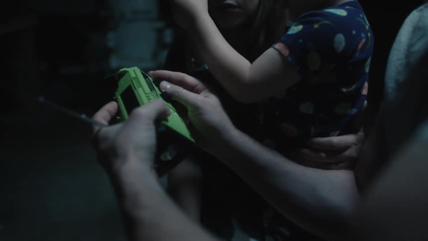 Family uses flashlight and battery portable pocket radio during power outage
