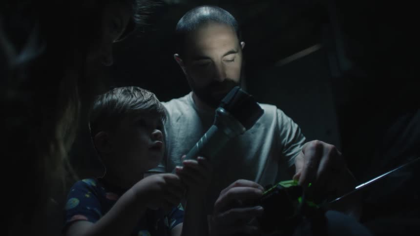 A father and son working in the dark