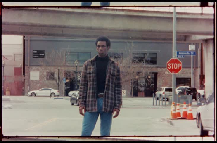 Black man standing in the street poses for the camera