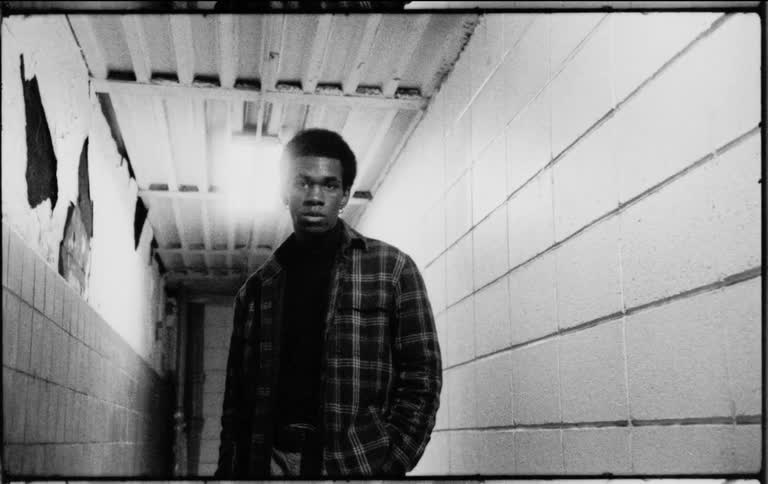 Young man stands in a hallway modeling for the camera