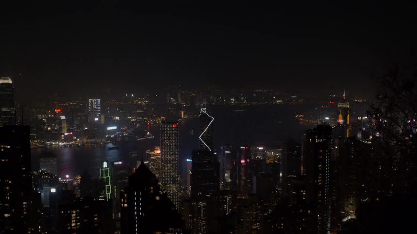 The lights flash on the buildings in the skyline at night